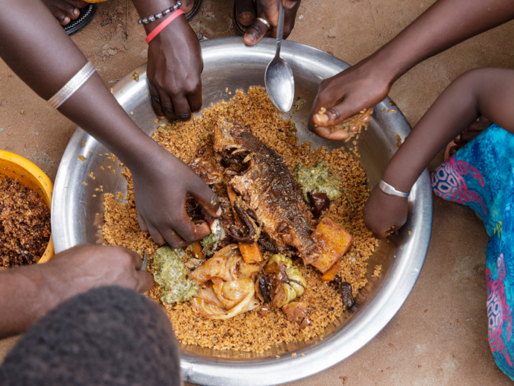 many hands eating fish foods from Africa