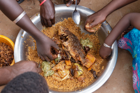 many hands eating fish foods from Africa
